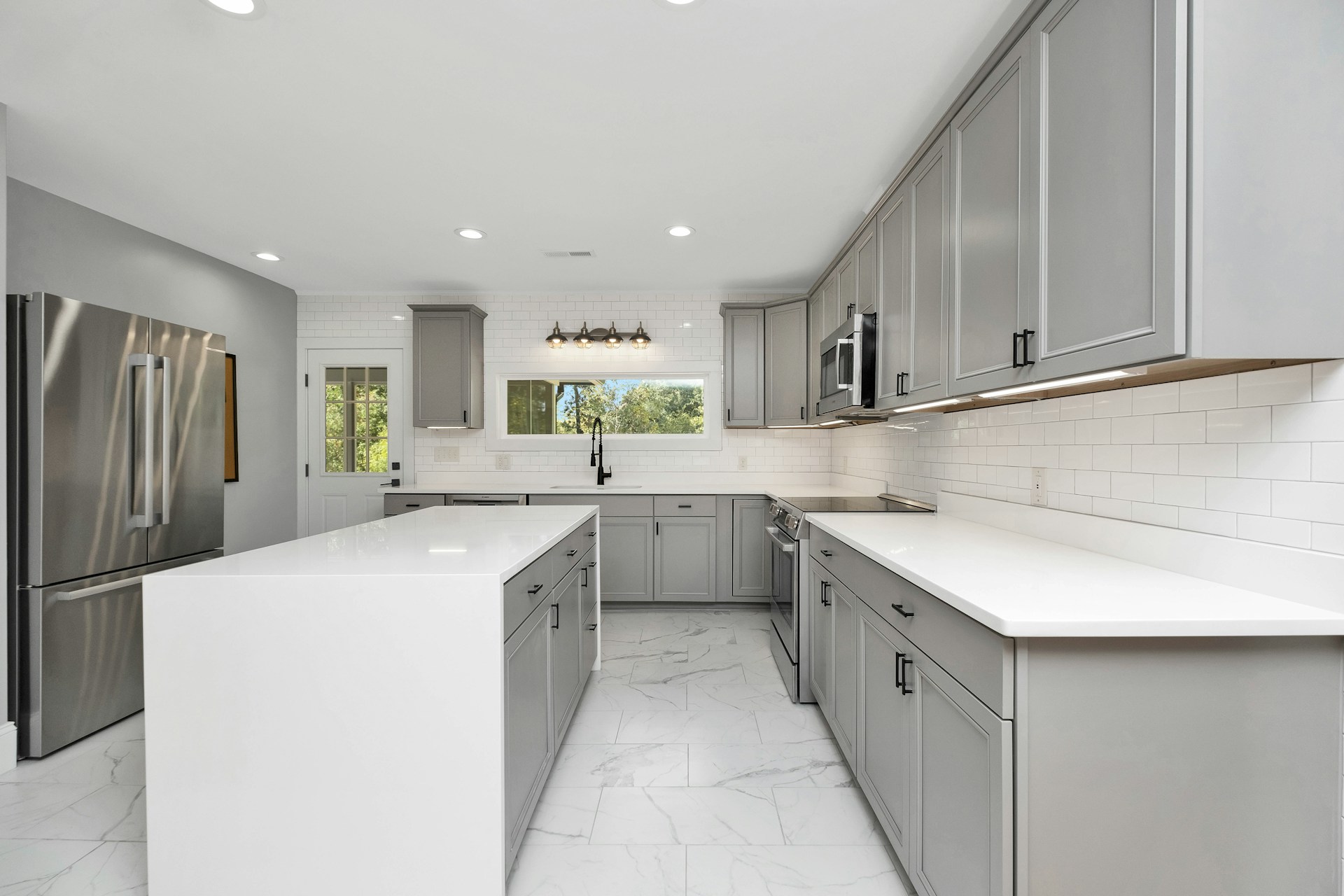 Modern kitchen with gray shaker cabinets, quartz island, and stainless appliances — Monterey County kitchen remodel
