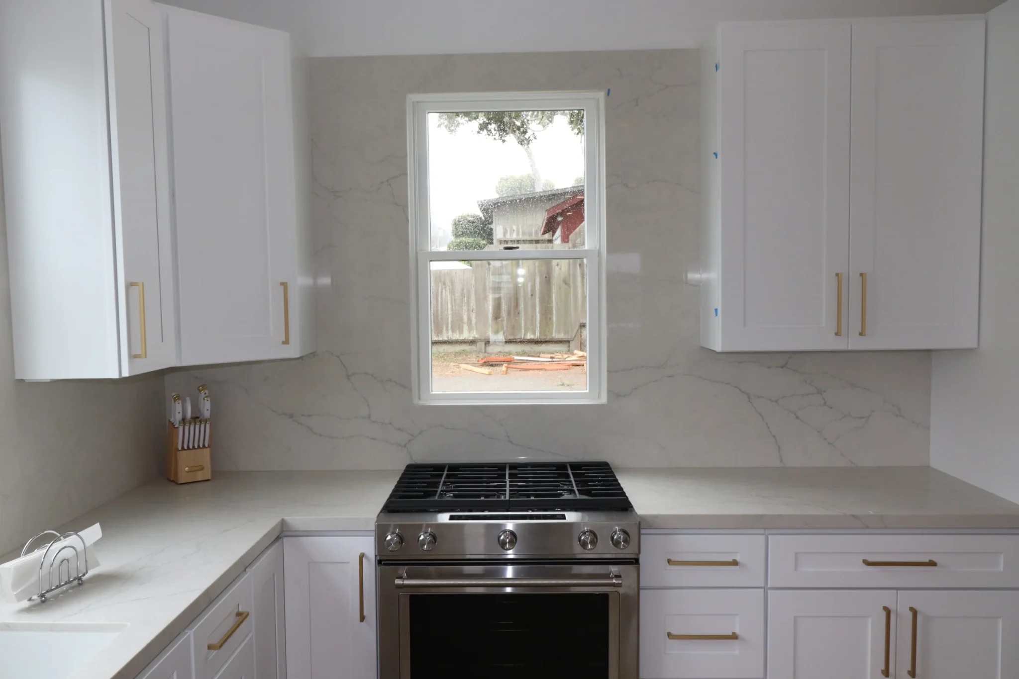 Partially completed white kitchen under construction showing mid-project renovation work in progress.